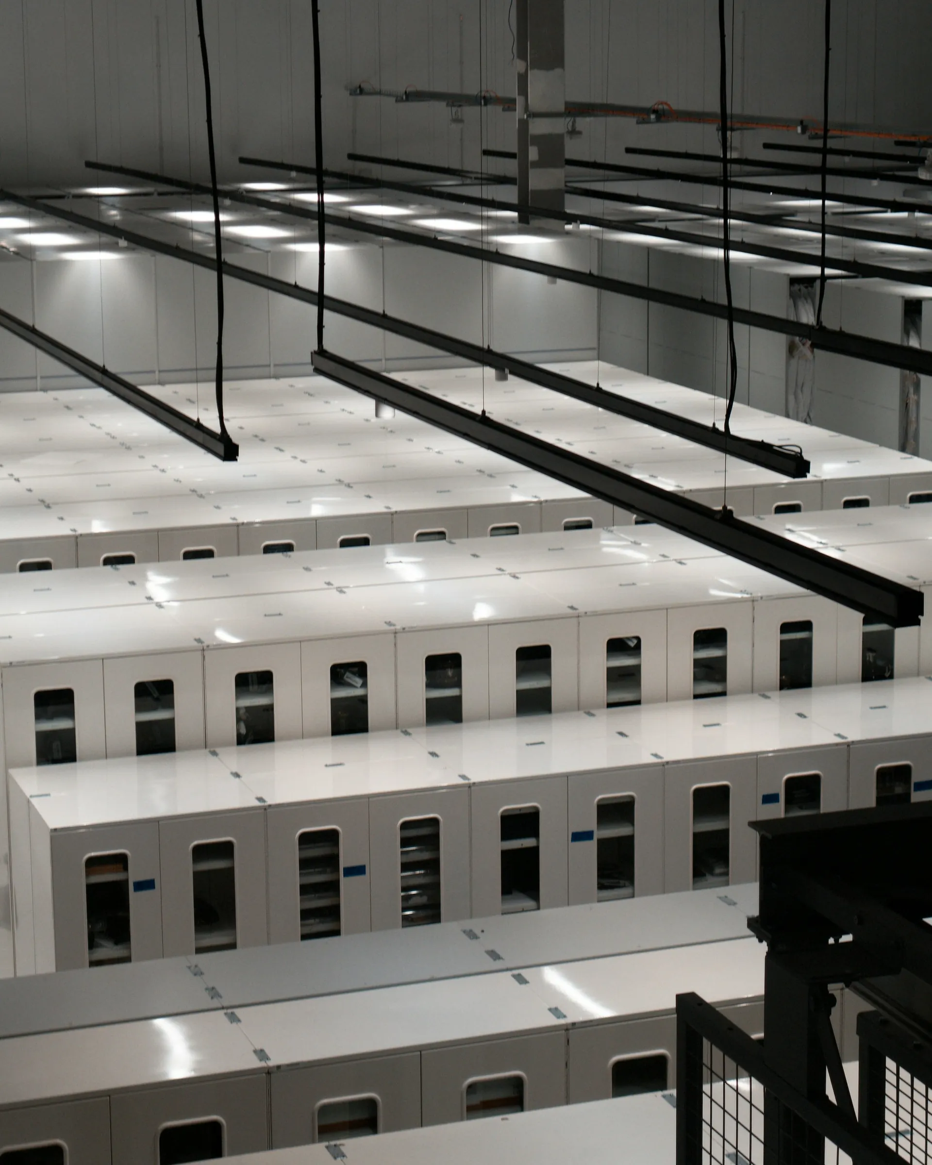 Aisle of white server cabinets in a modern data centre